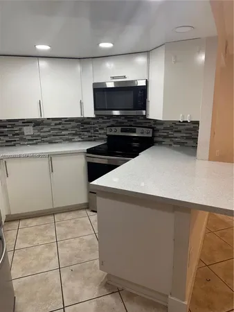 a kitchen with a sink a microwave and cabinets