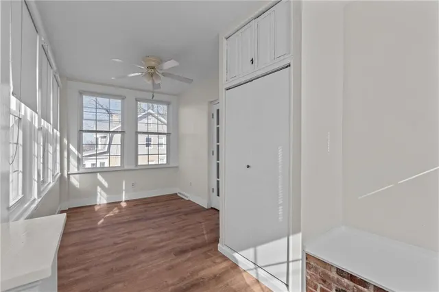 a view of an entryway with wooden floor and cabinet