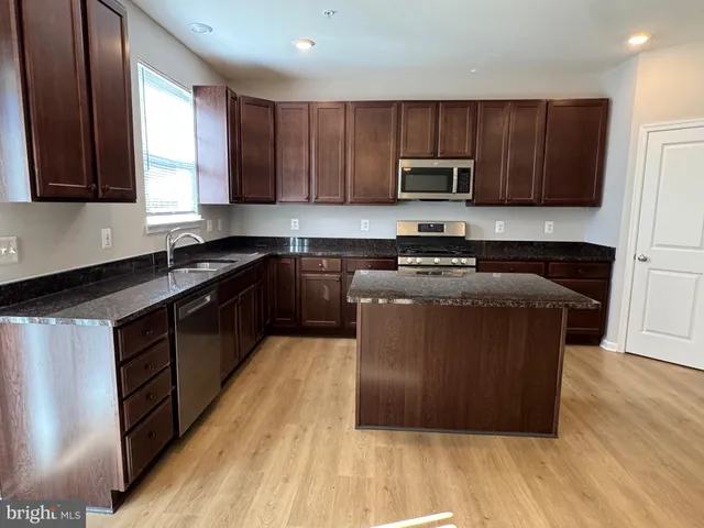 a kitchen with wooden floors and wooden cabinets