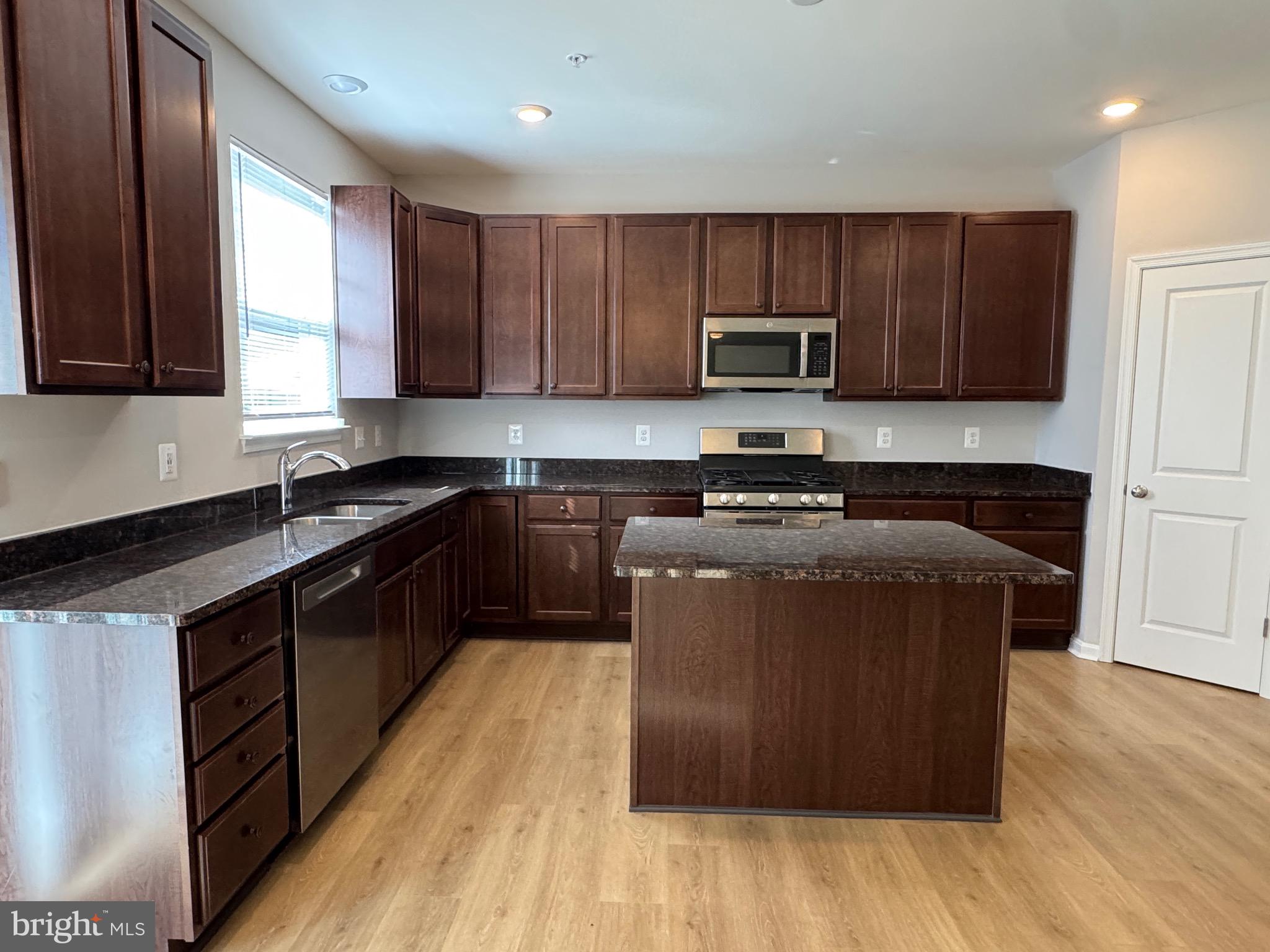 101 Albemarle Court Cambridge, MD 21613 - Photo 12 of 47 a kitchen with a sink a microwave a refrigerator and cabinets