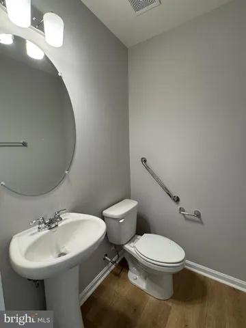 a bathroom with a toilet a sink and mirror