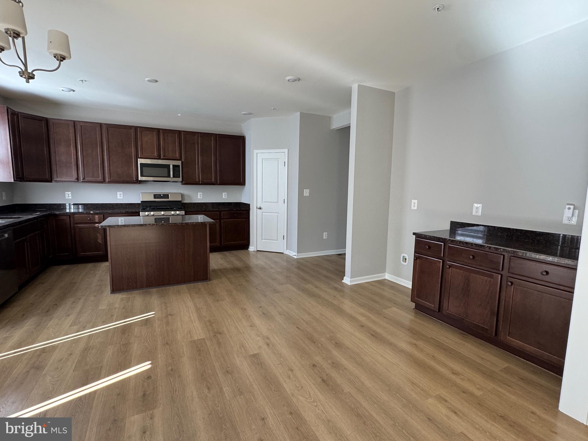 101 Albemarle Court Cambridge, MD 21613 - Photo 21 of 47 a kitchen with stainless steel appliances granite countertop a refrigerator a stove top oven a sink and dishwasher