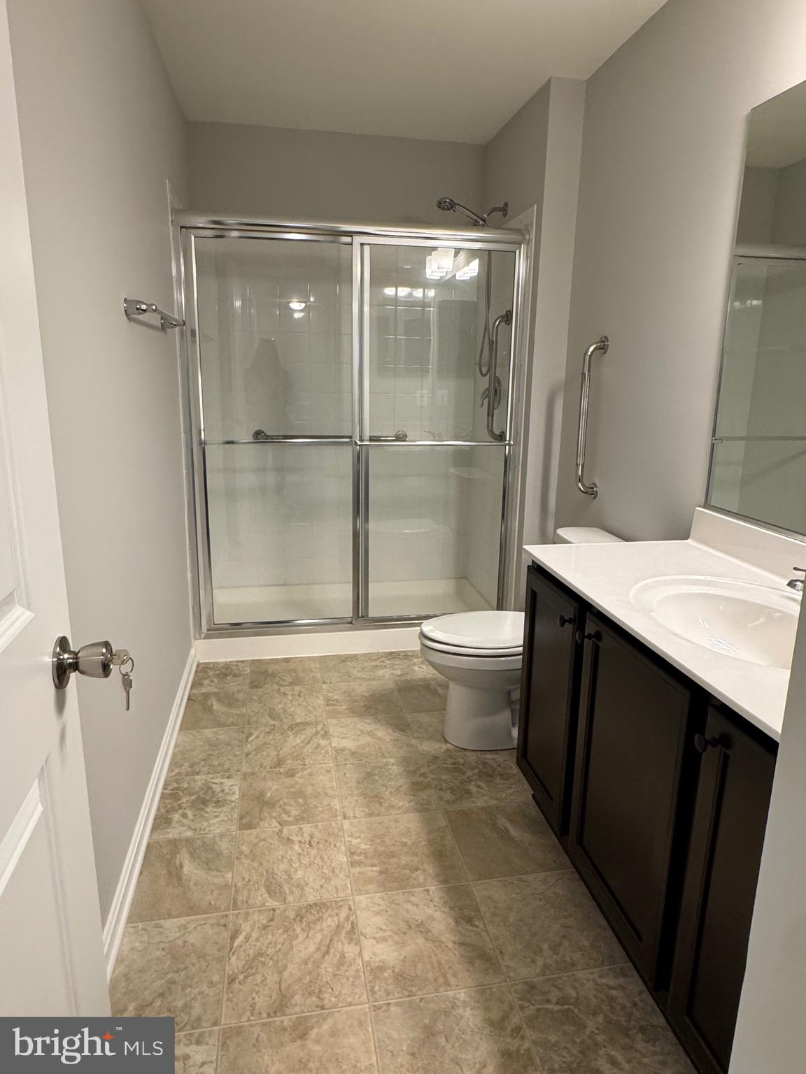 101 Albemarle Court Cambridge, MD 21613 - Photo 32 of 47 a bathroom with a granite countertop sink a toilet a mirror and shower