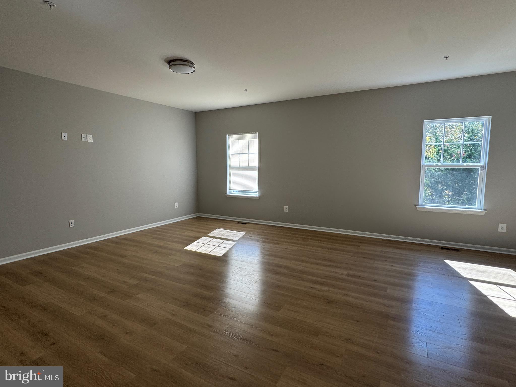 101 Albemarle Court Cambridge, MD 21613 - Photo 47 of 47 an empty room with wooden floor and windows