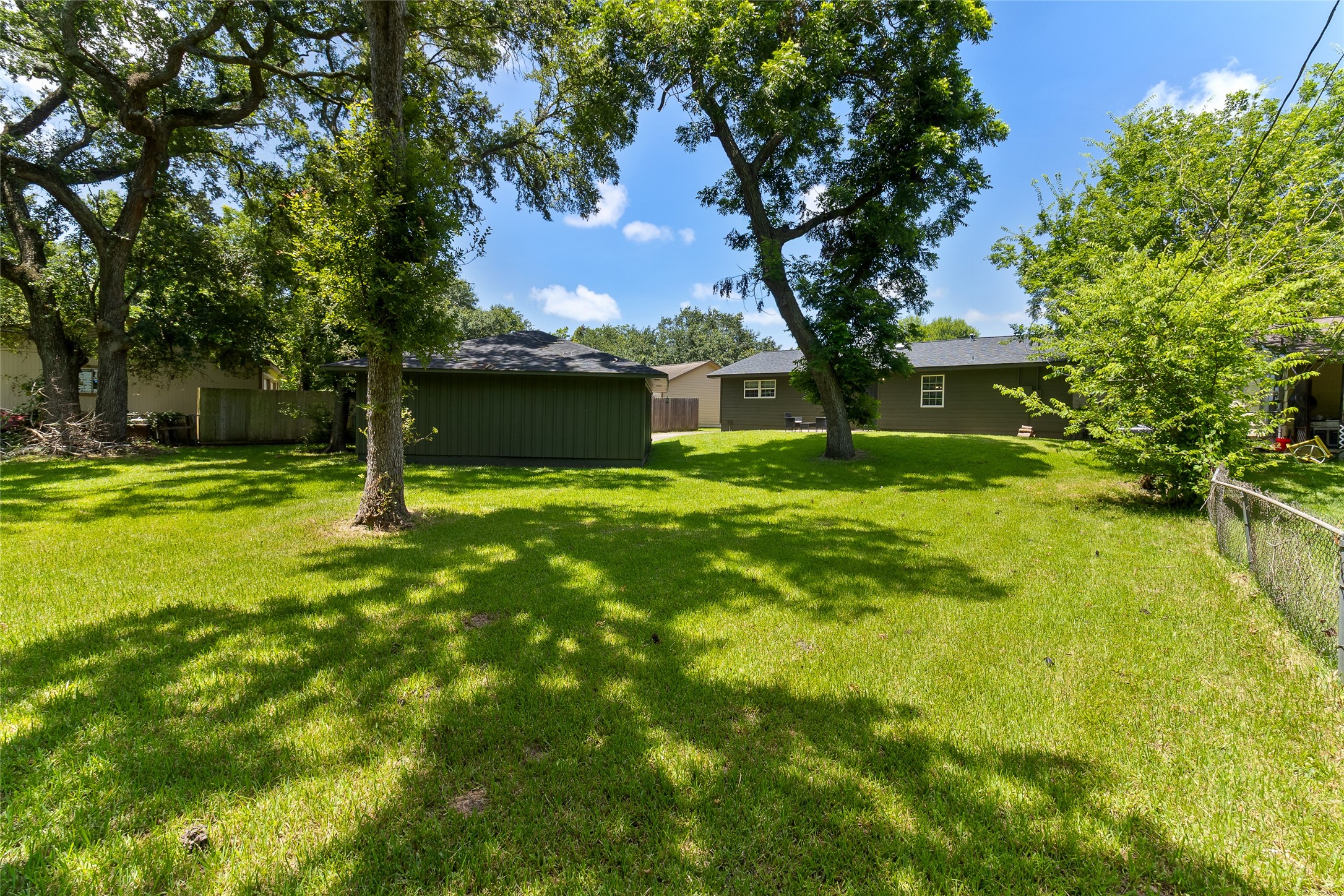 117 Cannon Street Clute, TX 77531 - Photo 5 of 24 Mature trees and open green space give the 0.415 acre lot a peaceful feel, with plenty of room to garden, play, entertain or simply enjoy the shade.