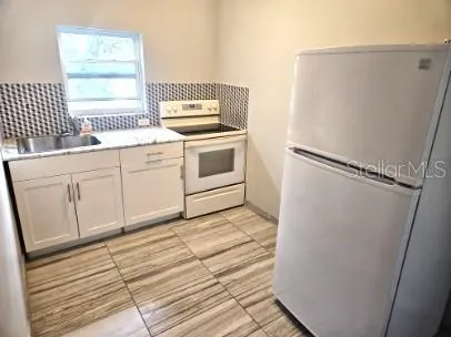 a kitchen with a cabinets and white appliances