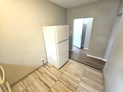 a view of a room with wooden floor and a hallway