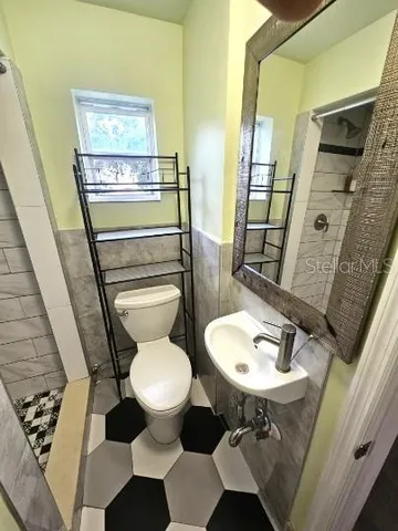 a bathroom with a sink toilet and mirror