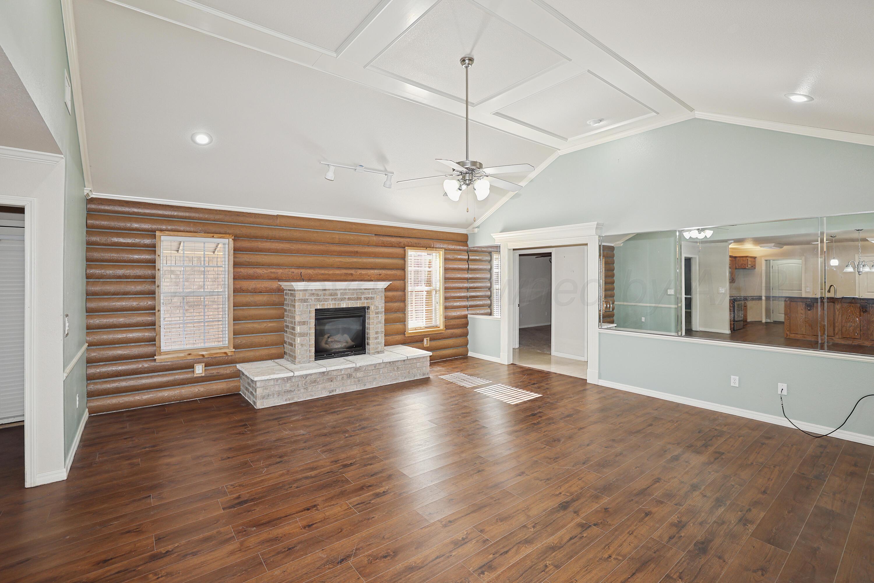 6709 Mosley Street Amarillo, TX 79119 - Photo 6 of 29 an empty room with wooden floor and a window
