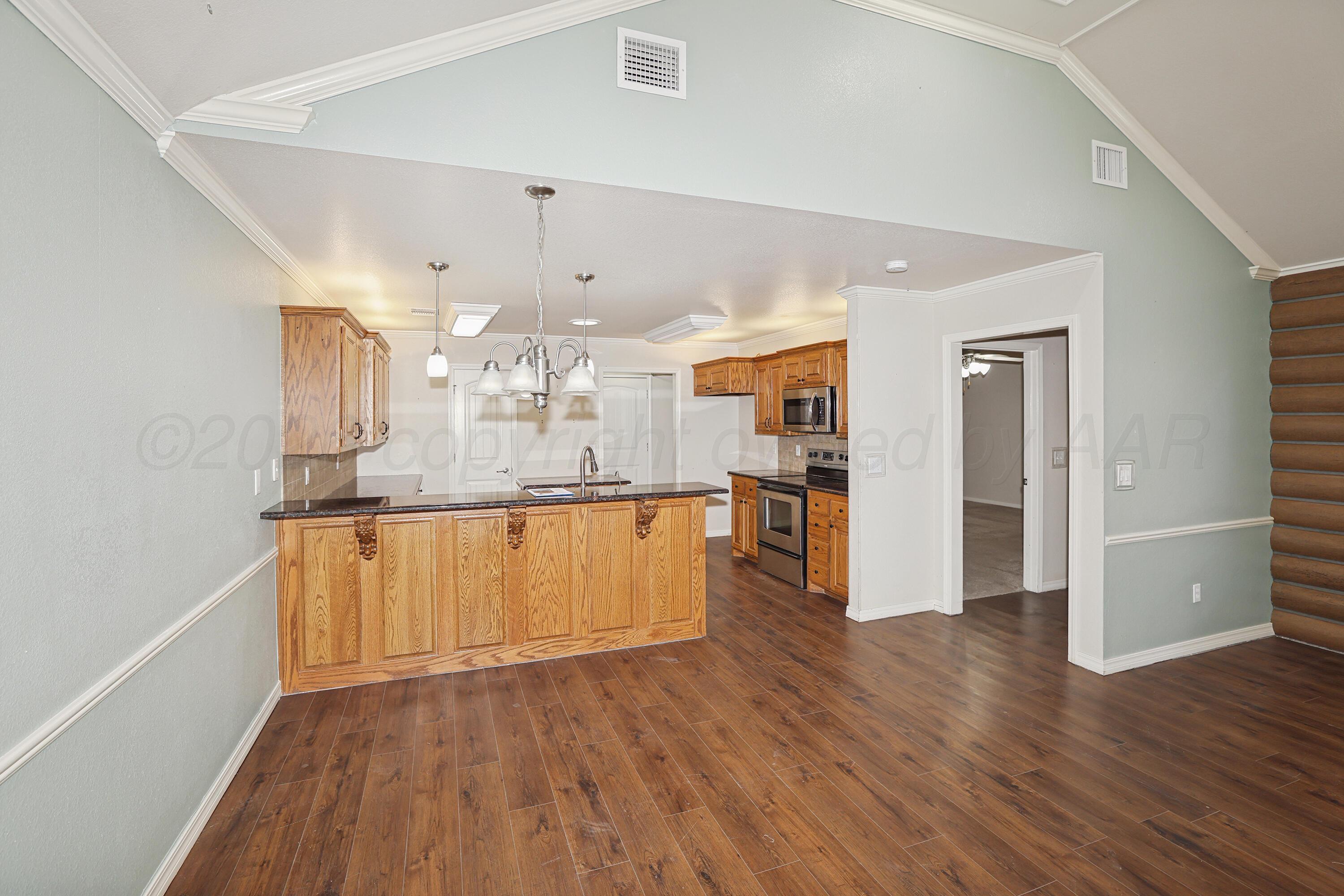 6709 Mosley Street Amarillo, TX 79119 - Photo 7 of 29 a view of a kitchen with wooden floor and a window
