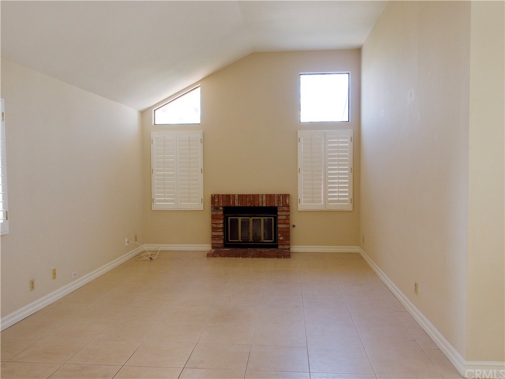 15 Robinsong, Unit 160 Irvine, CA 92614 - Photo 4 of 31 Living room with vaulted ceilings, fireplace and plantation shutters