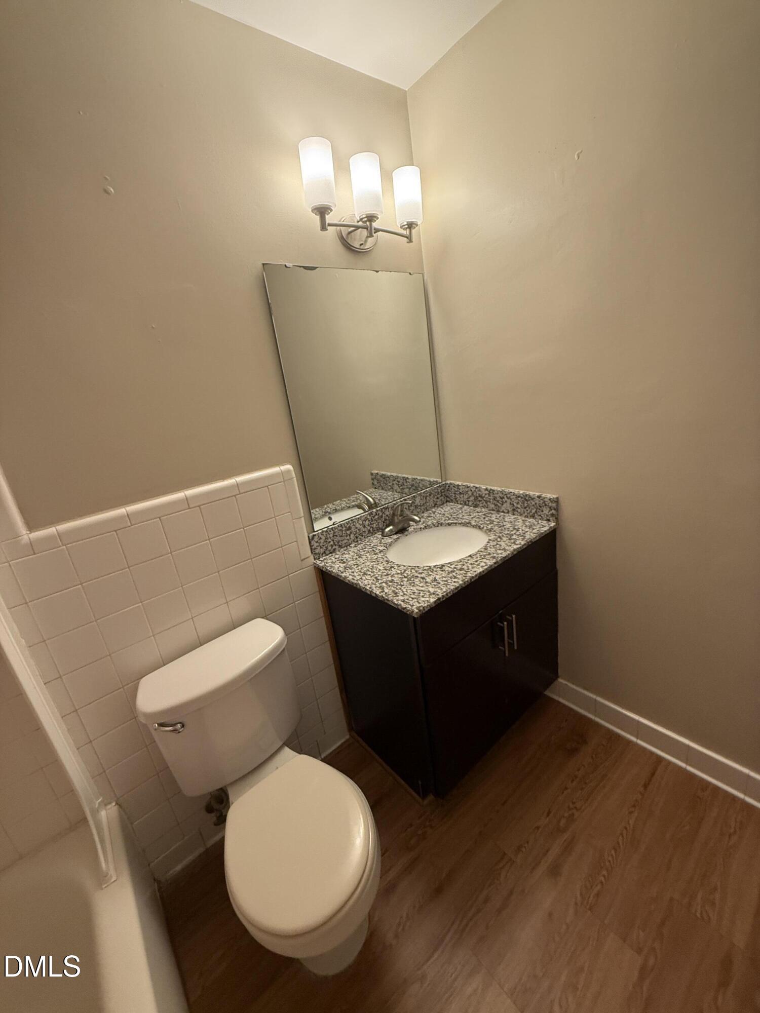 2616 Noble Road, Unit D Raleigh, NC 27608 - Photo 7 of 9 a bathroom with a toilet a sink and mirror