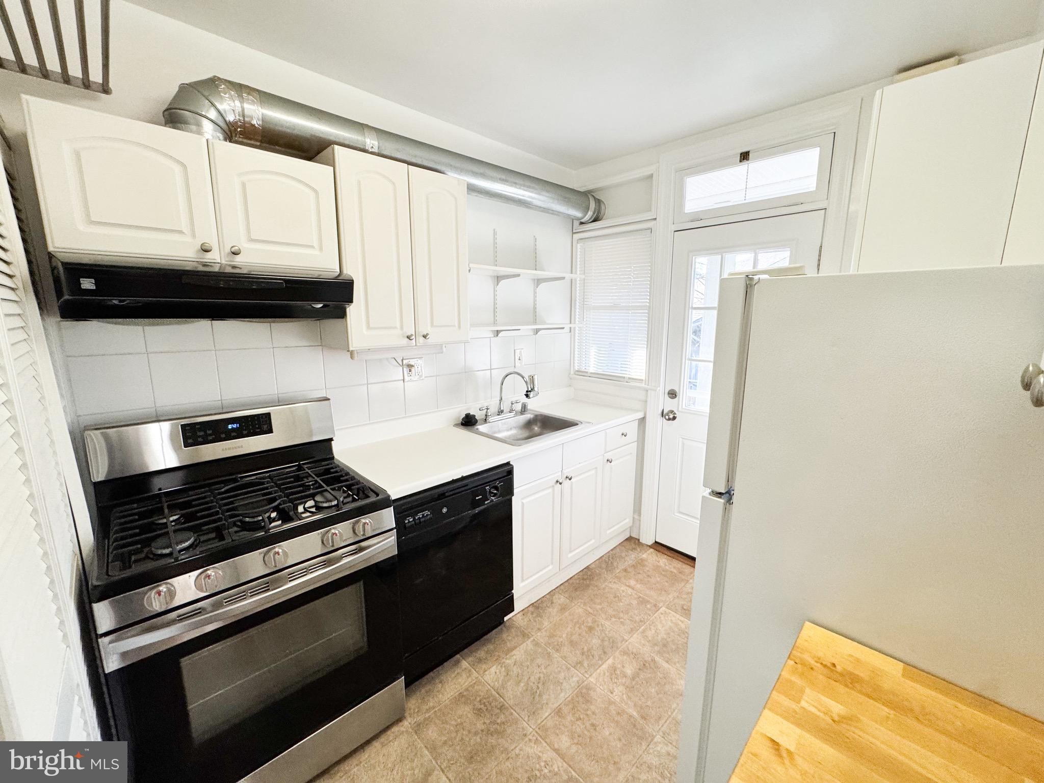 4348 Ellicott Street Northwest, Unit 3 Washington, DC 20016 - Photo 13 of 16 a kitchen with stainless steel appliances granite countertop a stove a sink and a refrigerator