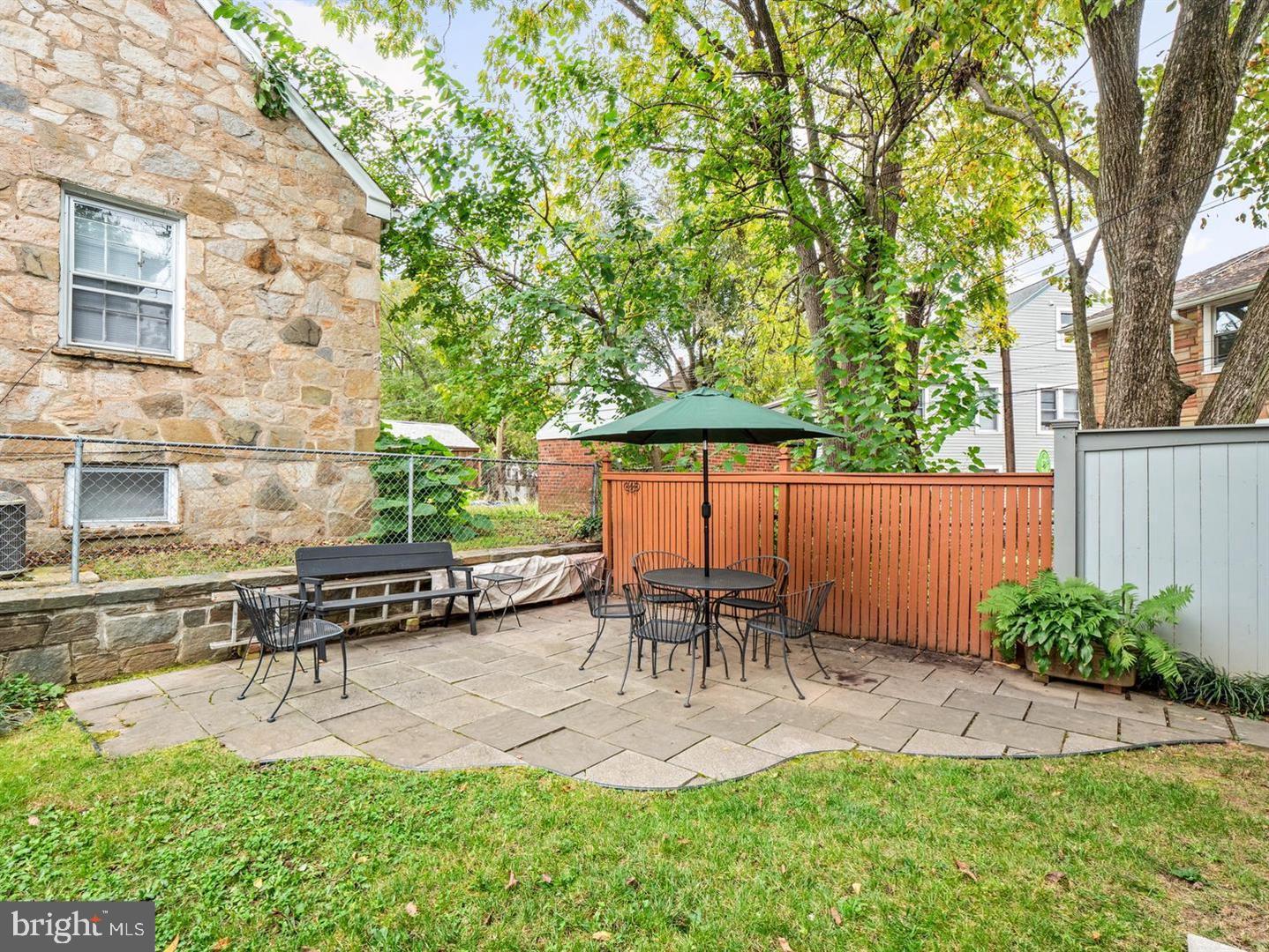 4348 Ellicott Street Northwest, Unit 3 Washington, DC 20016 - Photo 2 of 16 a view of patio with table and chairs potted plants and large tree