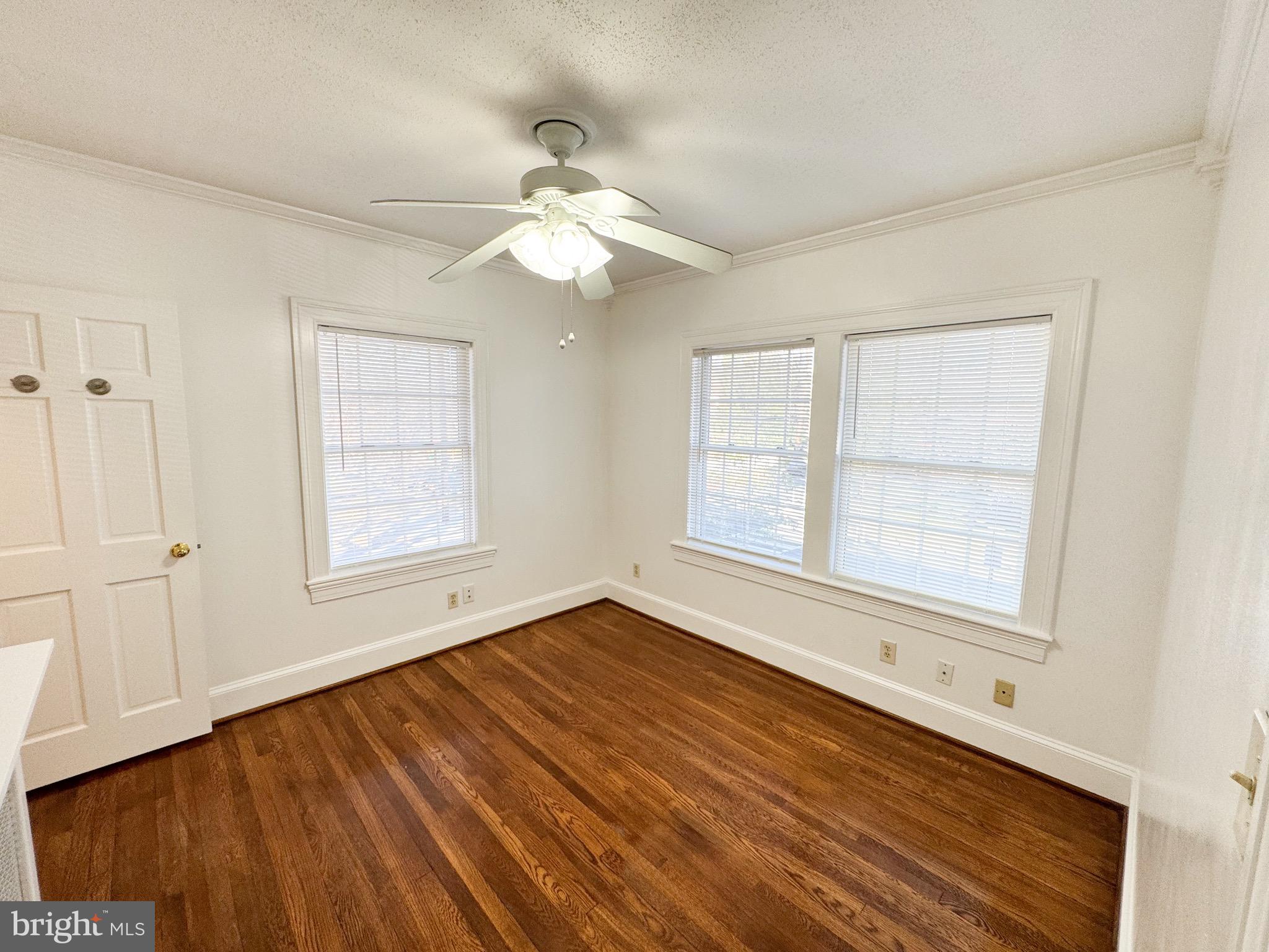 4348 Ellicott Street Northwest, Unit 3 Washington, DC 20016 - Photo 4 of 16 an empty room with wooden floor chandelier fan and windows