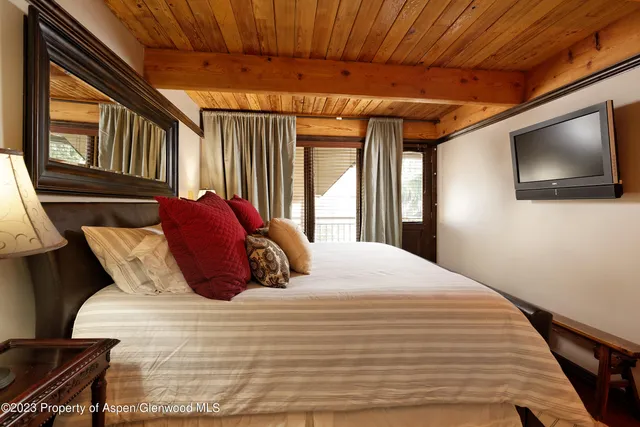 a bedroom with double bed and a flat tv screen