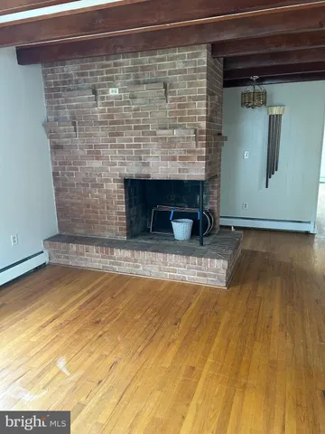 a view of empty room with wooden floor and fireplace