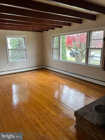 a view of a room with wooden floor and a window