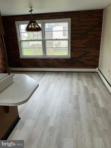 a view of a room with wooden floor and a window