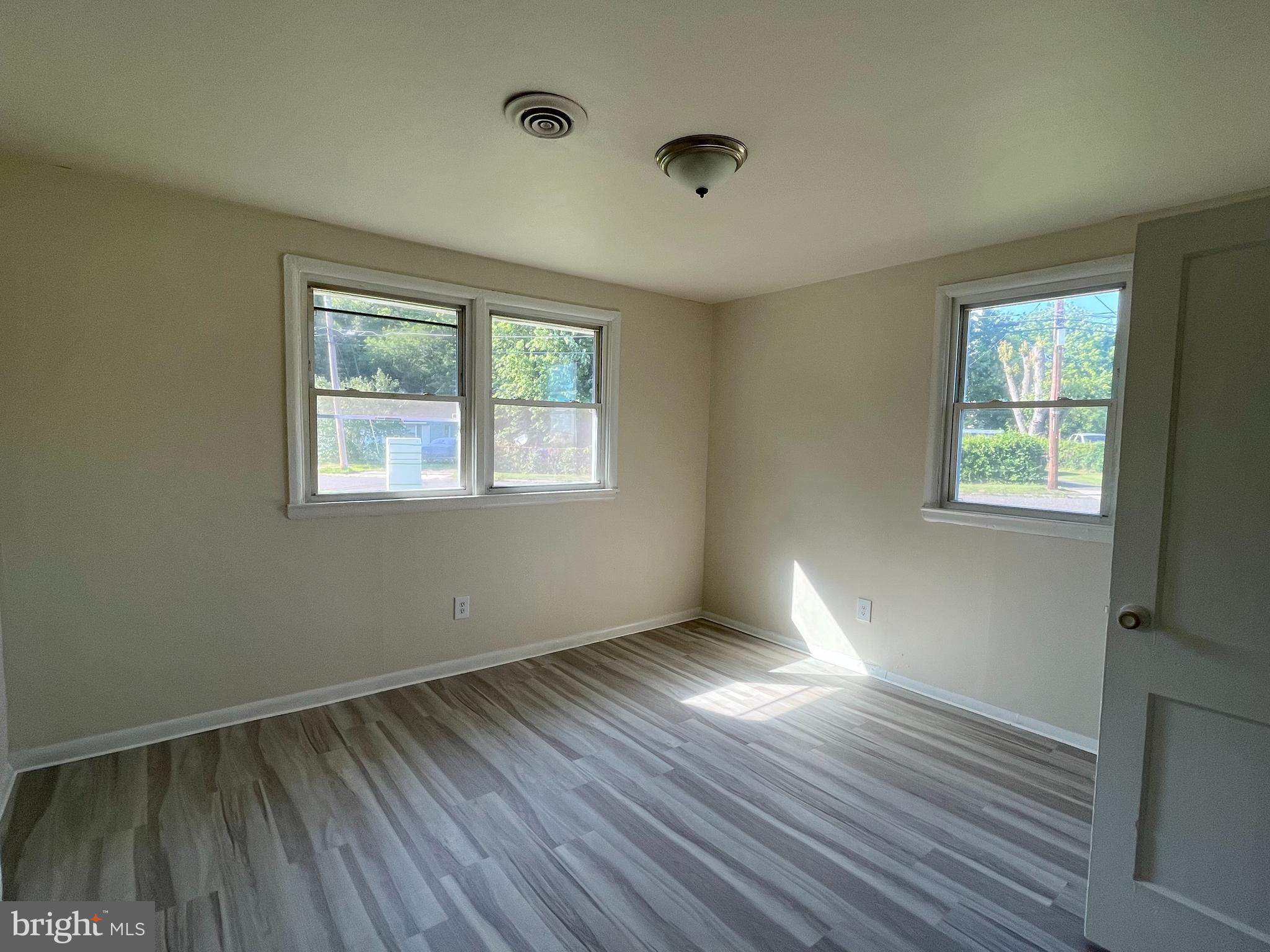 227 Kinsley Road Pemberton, NJ 08068 - Photo 11 of 18 an empty room with wooden floor and windows