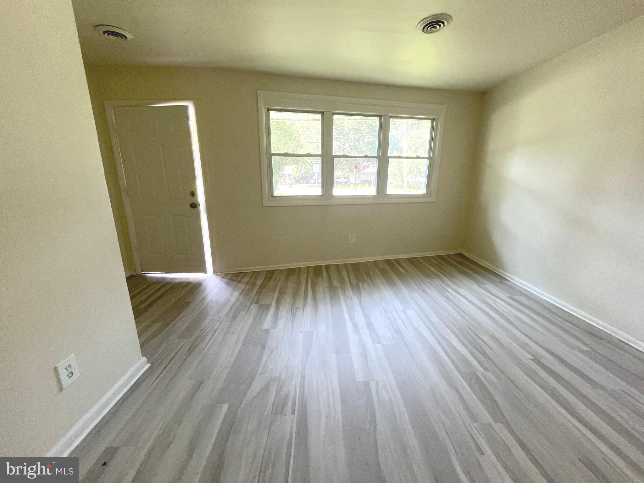 227 Kinsley Road Pemberton, NJ 08068 - Photo 2 of 18 an empty room with wooden floor and windows