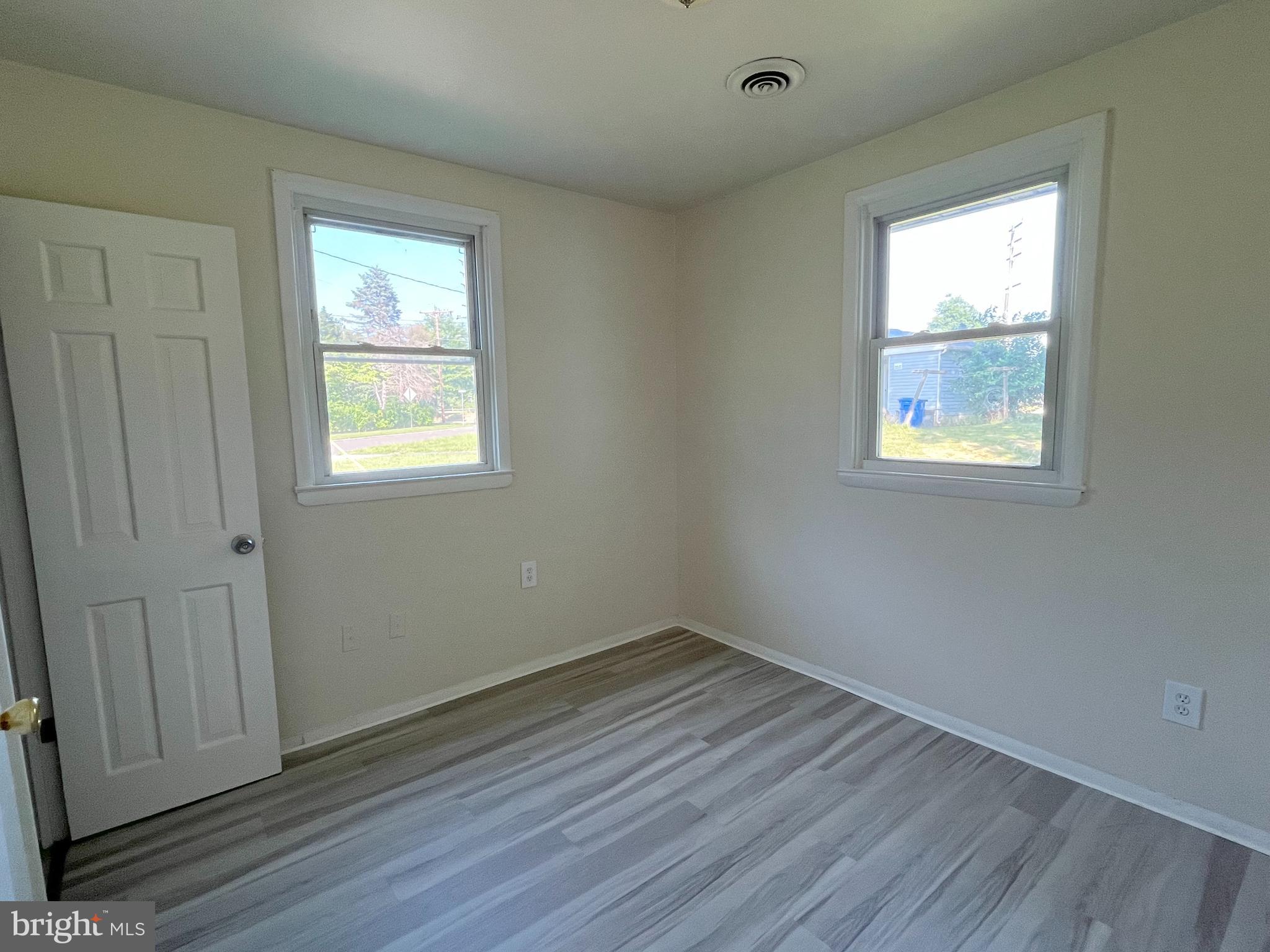 227 Kinsley Road Pemberton, NJ 08068 - Photo 10 of 18 an empty room with wooden floor and windows