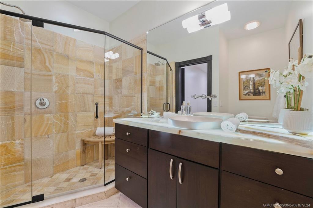24 Ridgeland Drive Stuart, FL 34996 - Photo 33 of 99 a bathroom with a double vanity sink mirror and shower
