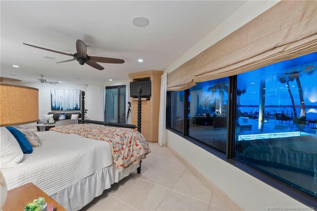 24 Ridgeland Drive Stuart, FL 34996 - Photo 46 of 99 a spacious bedroom with a bed and a chandelier