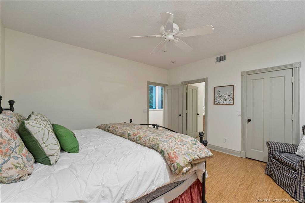24 Ridgeland Drive Stuart, FL 34996 - Photo 73 of 99 a bedroom with a large bed and a chandelier