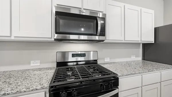 a kitchen with granite countertop a stove and a microwave