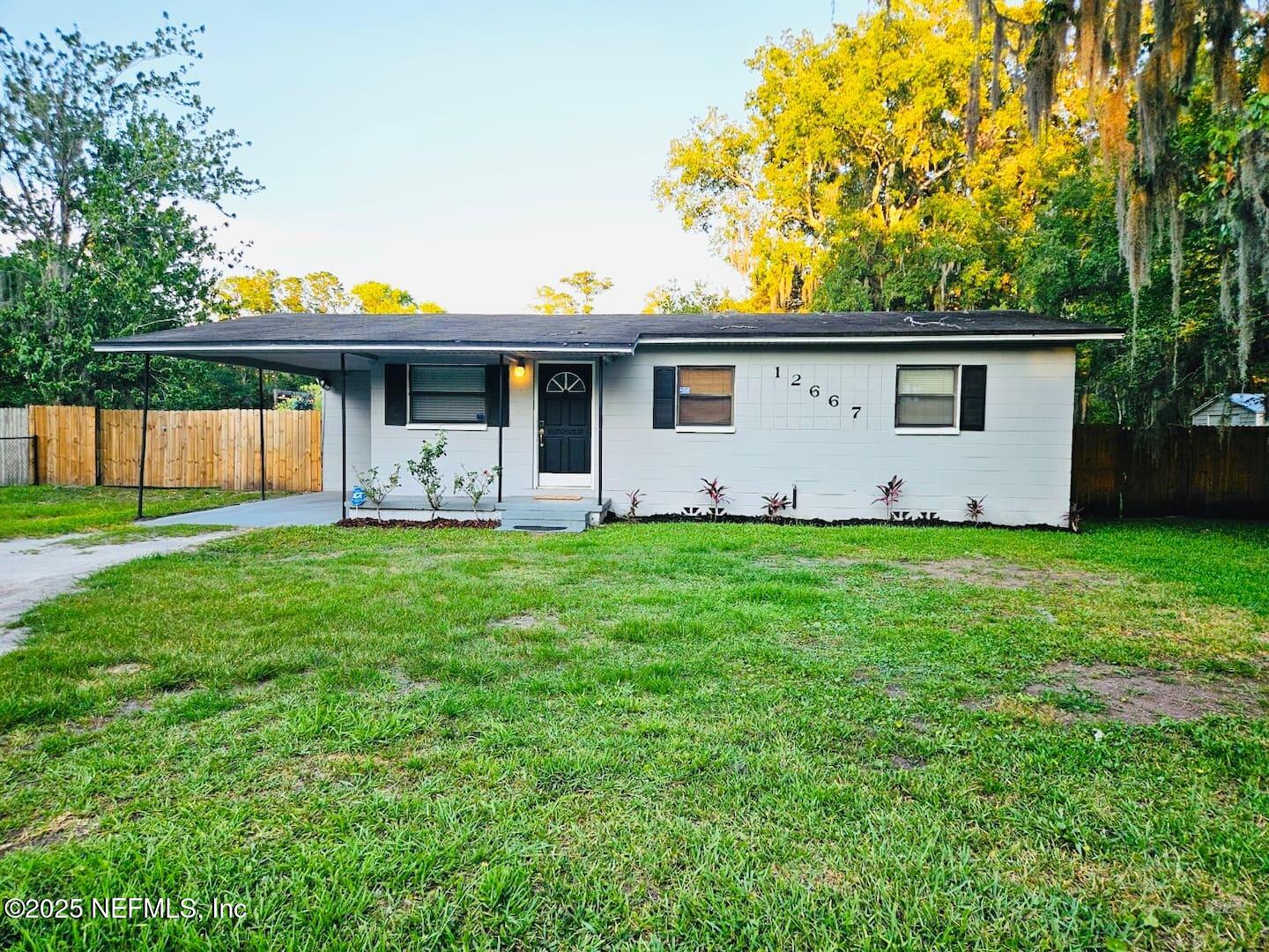 a view of a house with backyard and a garden
