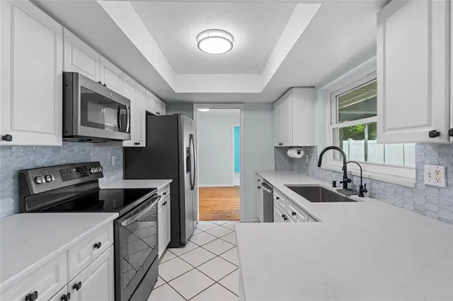 a kitchen with stainless steel appliances granite countertop a sink stove and a refrigerator
