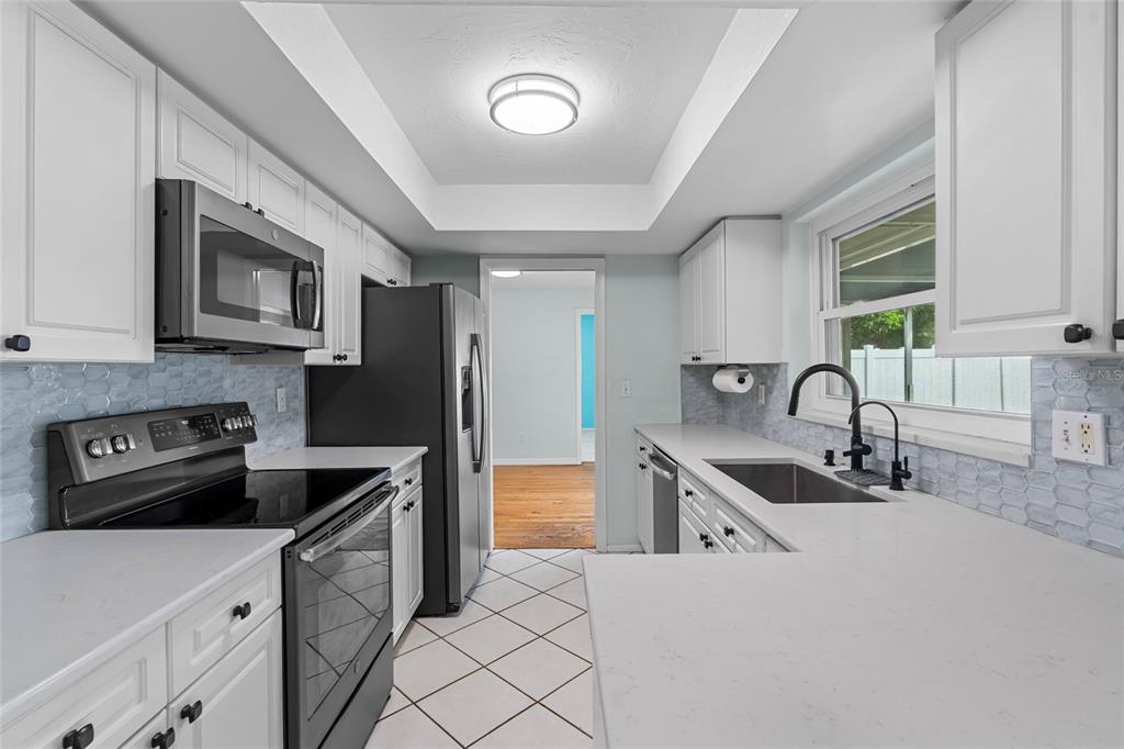 13236 84th Terrace Seminole, FL 33776 - Photo 14 of 34 a kitchen with stainless steel appliances granite countertop a sink stove and a refrigerator