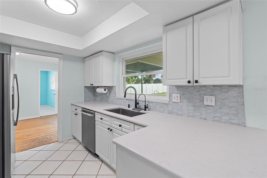 13236 84th Terrace Seminole, FL 33776 - Photo 15 of 34 a kitchen with kitchen island granite countertop a sink cabinets and window