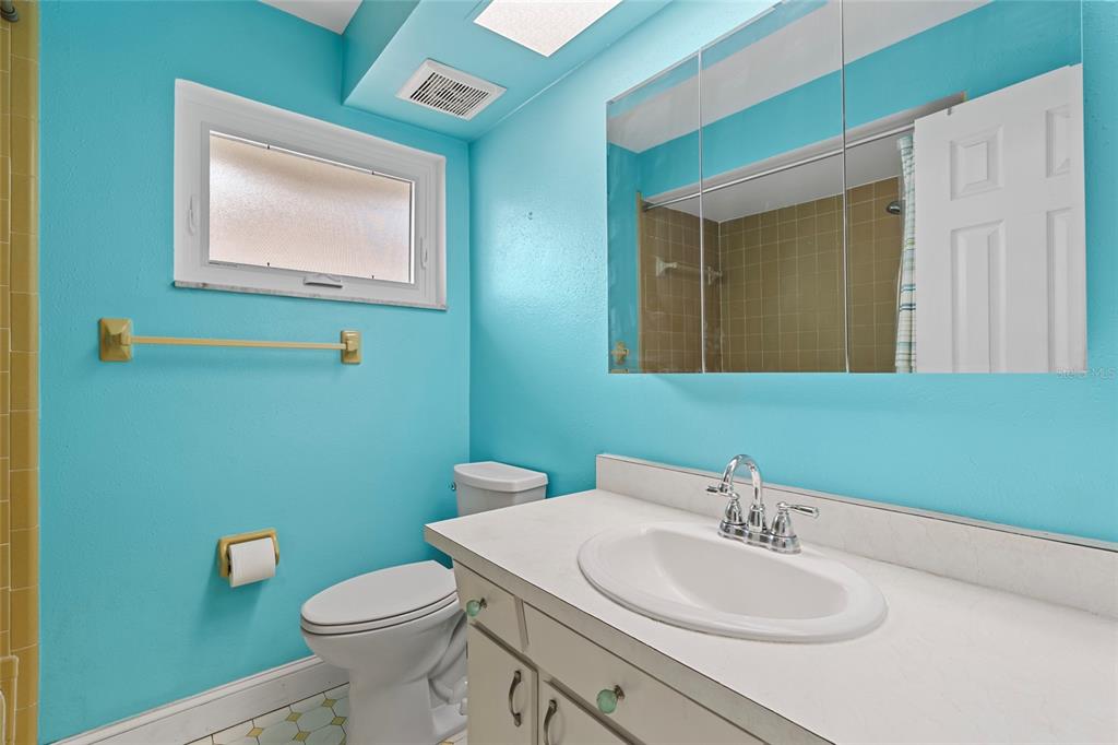 13236 84th Terrace Seminole, FL 33776 - Photo 20 of 34 a bathroom with a toilet sink and mirror
