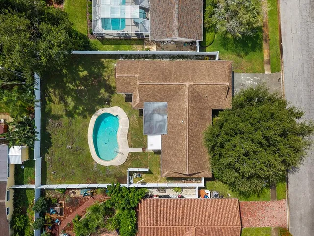 an aerial view of a house with a garden space and a bench