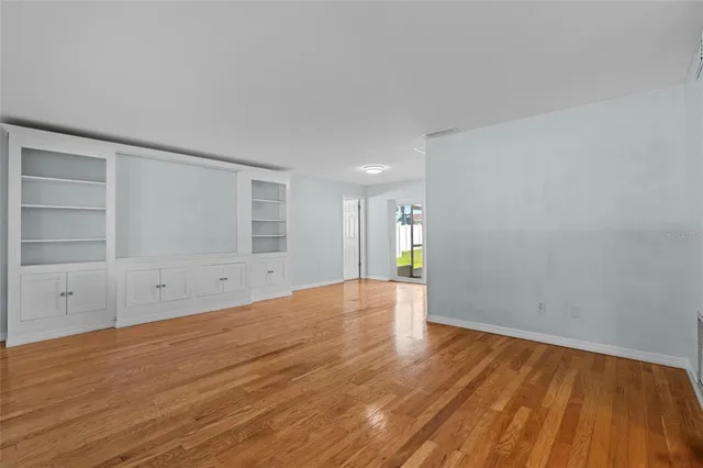 a view of empty room with wooden floor and entryway