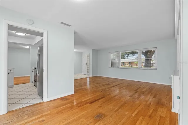 a view of empty room with wooden floor