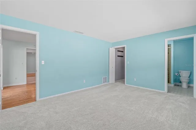an empty room with closet and bathroom