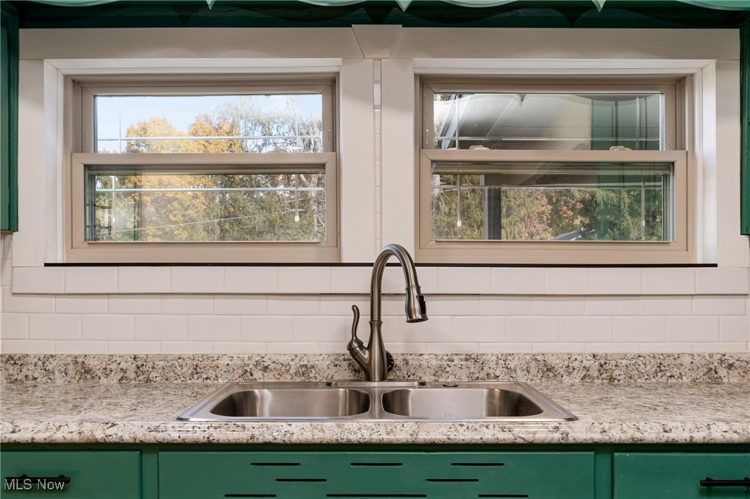 724 Garden Road Zanesville, OH 43701 - Photo 10 of 22 Kitchen view of green cabinets, decorative backsplash, and light stone counters