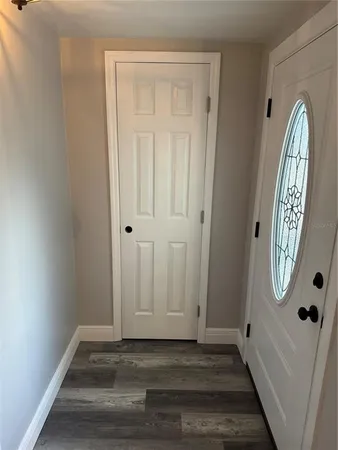 a view of a livingroom with wooden floor and a mirror