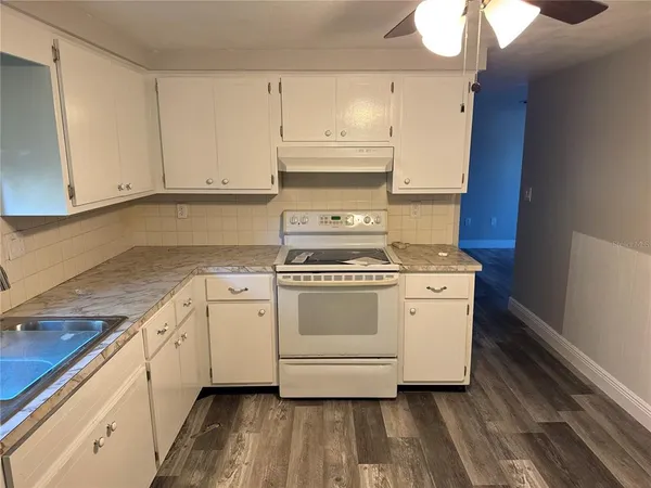 a kitchen with granite countertop white cabinets and white appliances