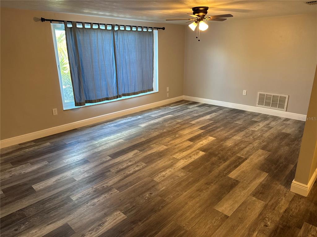 7540 Venice Drive Port Richey, FL 34668 - Photo 7 of 9 a view of an empty room with a ceiling fan