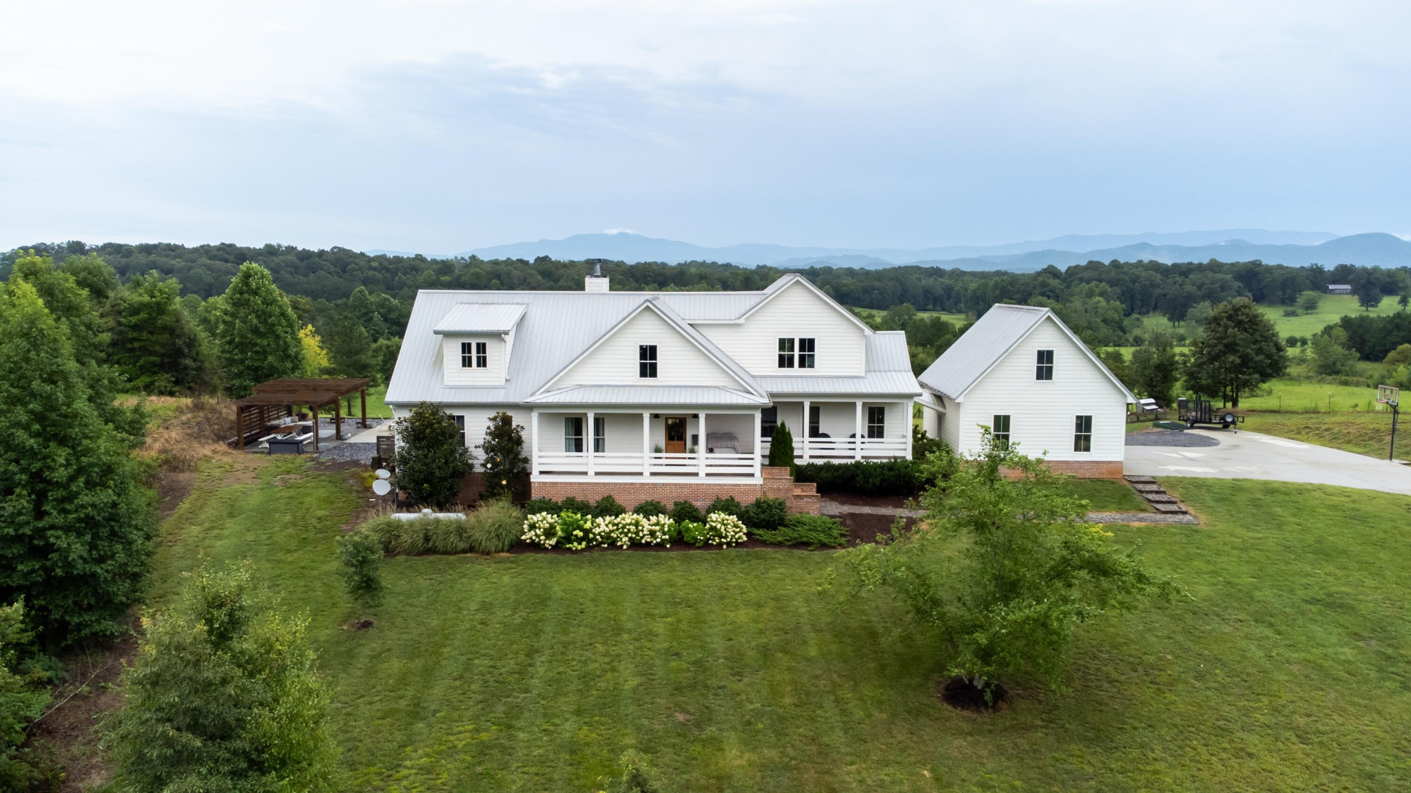 6925 Spring Place Road Southeast Old Fort, TN 37362 - Photo 4 of 46 a view of a white house with a big yard and large trees