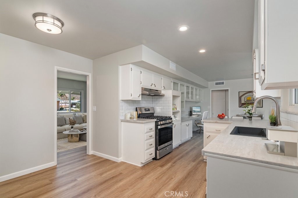 28548 Middlebury Way Menifee, CA 92586 - Photo 13 of 15 a kitchen that has a sink cabinets stainless steel appliances and wooden floor