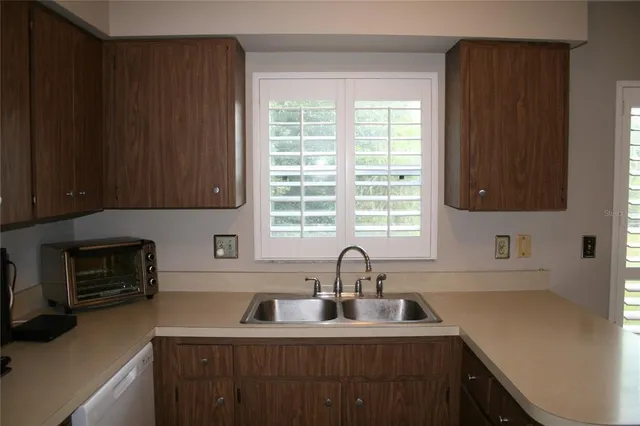 a kitchen with sink a window and cabinets