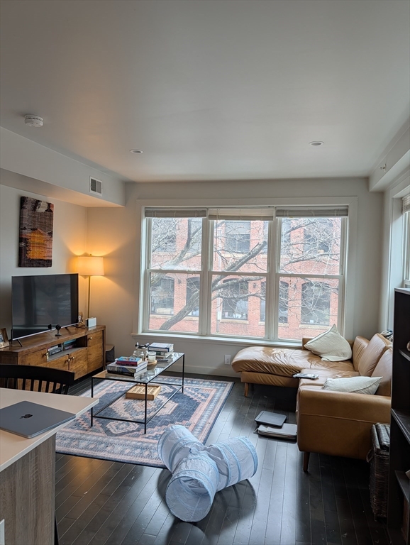 3383 Washington Street, Unit 201 Boston, MA 02130 - Photo 3 of 15 a living room with furniture and a flat screen tv
