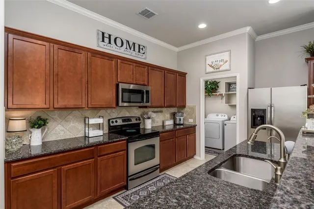 a kitchen with stainless steel appliances granite countertop a sink refrigerator and microwave