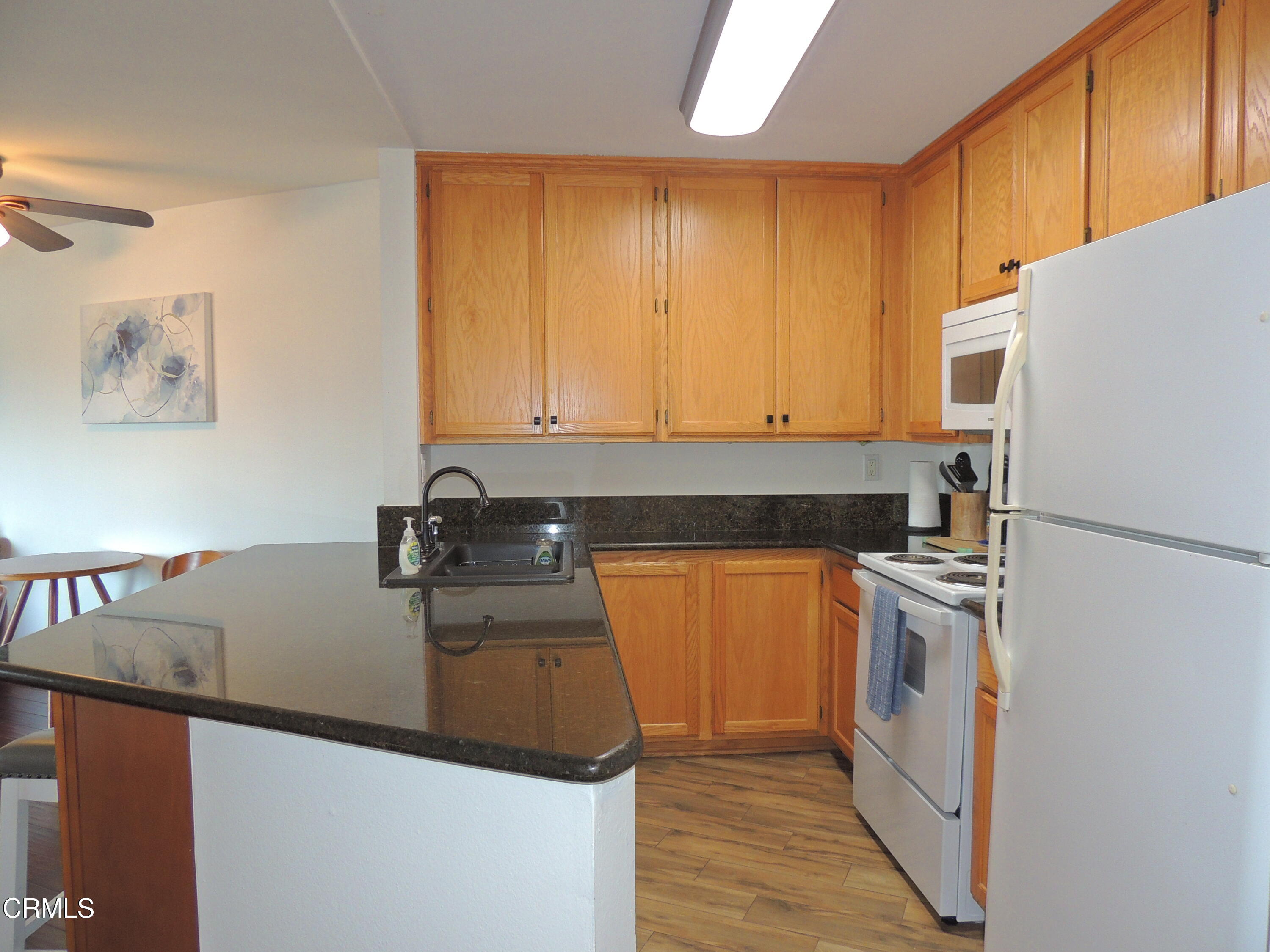 2901 Peninsula Road, Unit 237 Oxnard, CA 93035 - Photo 15 of 35 a kitchen with a sink a stove and a refrigerator