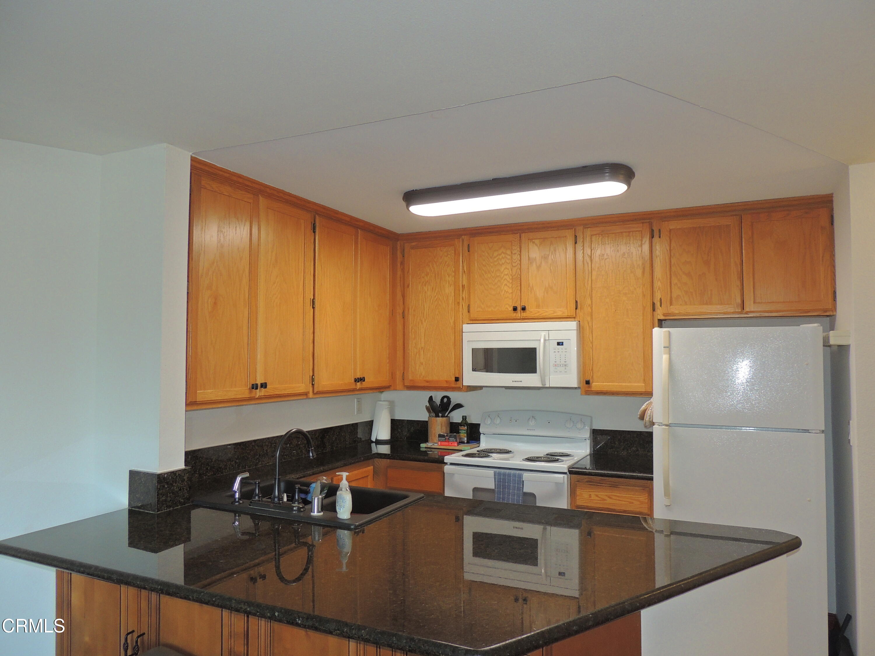 2901 Peninsula Road, Unit 237 Oxnard, CA 93035 - Photo 16 of 35 a kitchen with a refrigerator a stove a sink and cabinets